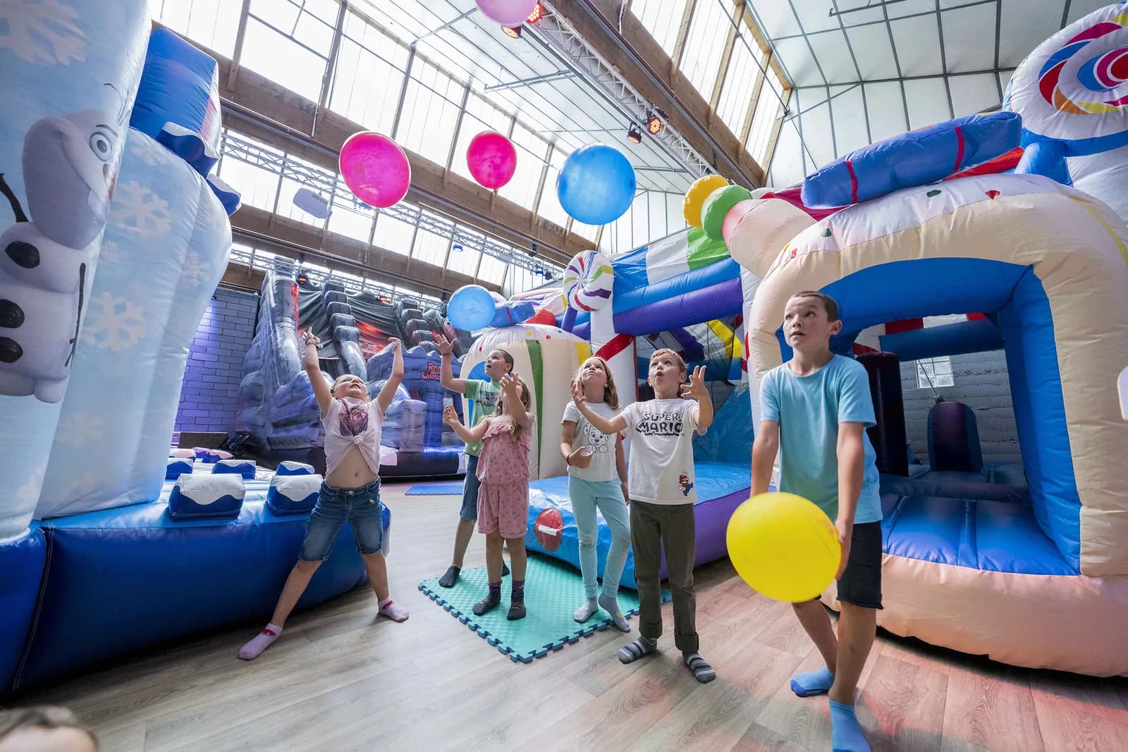 Enfants qui jouent avec des ballons parmi les structures
